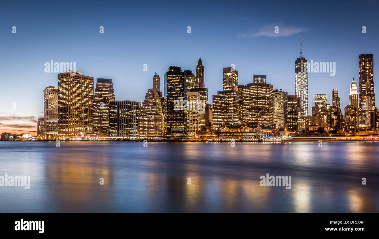 Lower Manhattan skyline over East River at dusk - New York Stock Photo
