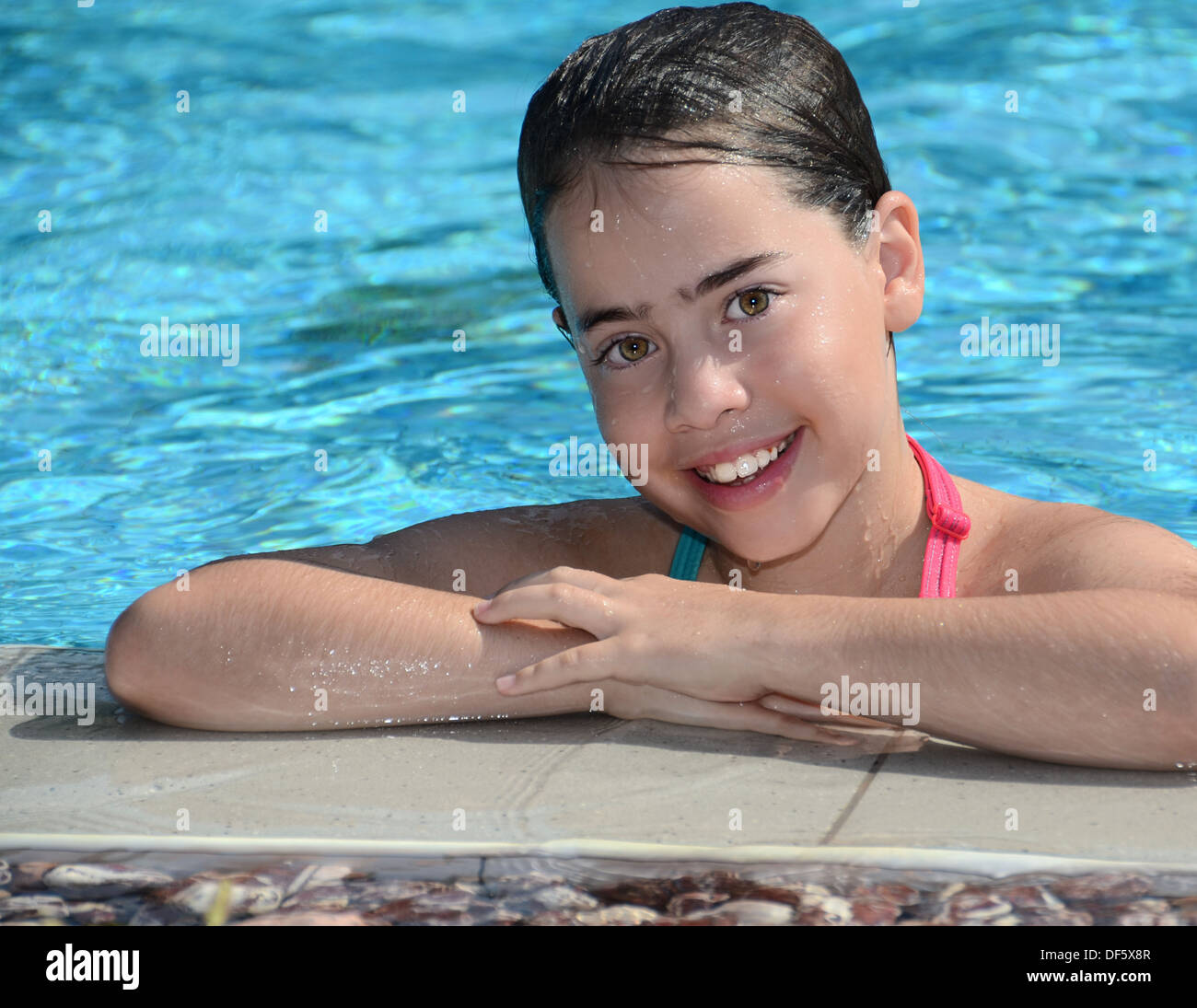 Teenager at the pool - 12 year old teenage girl relaxing at the pool Stock Photo
