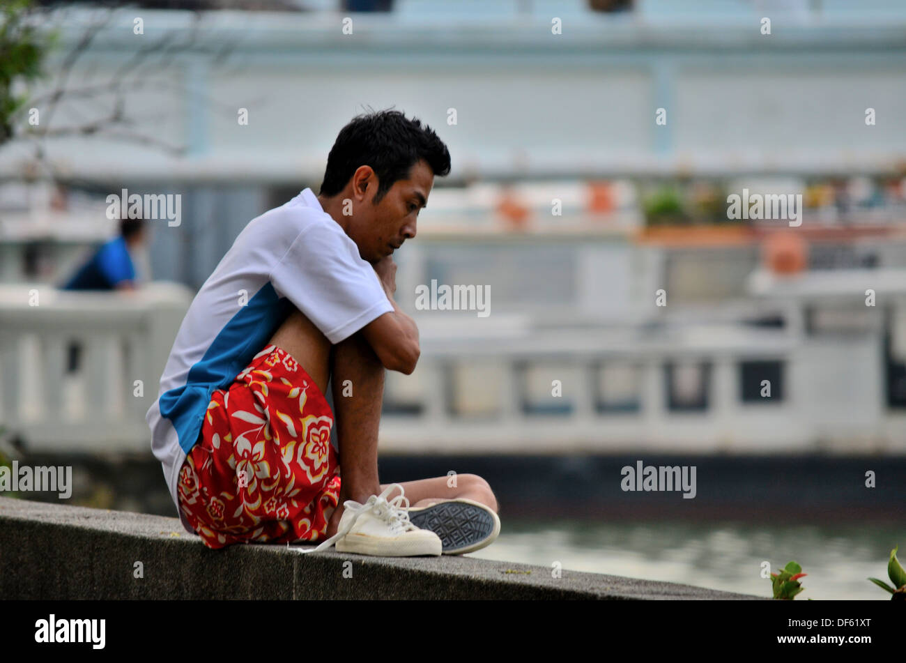 Man reflects on seaside wall, Singapore Stock Photo