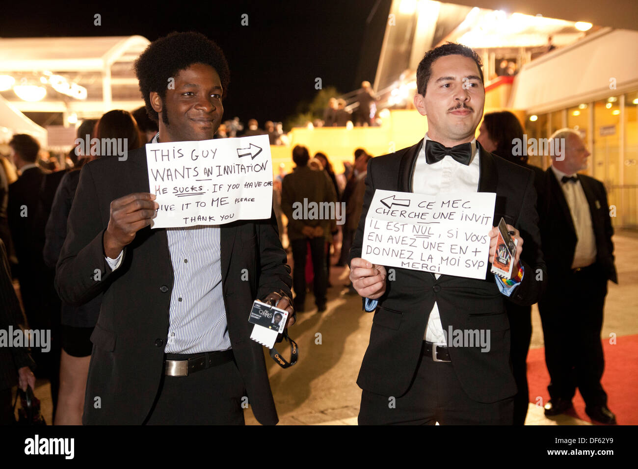 Festival goers hold signs asking for tickets to movie screenings at Le Festival International du Film de Cannes Stock Photo