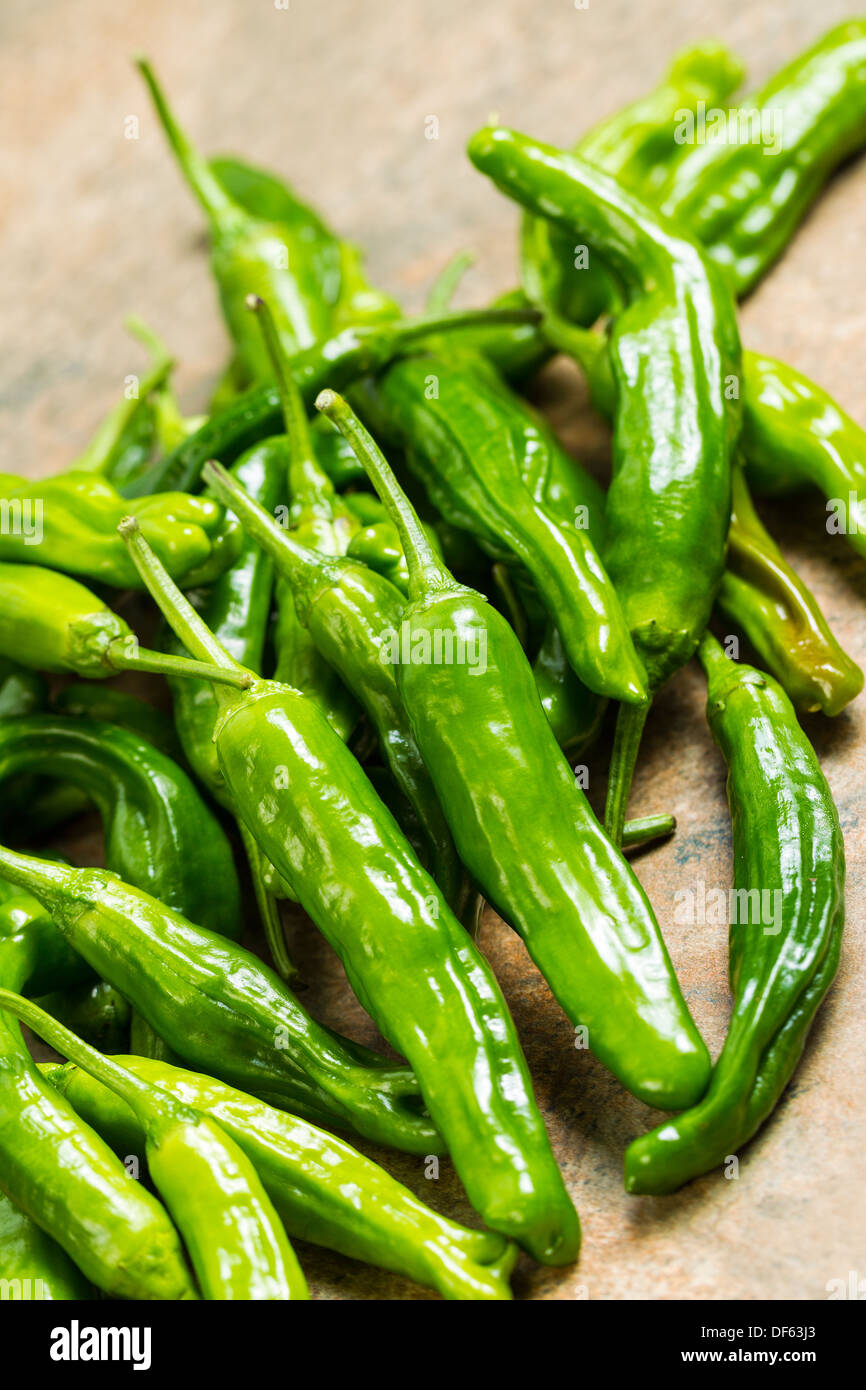 Closeup vertical photo of fresh, green sweet peppers on stone counter top Stock Photo