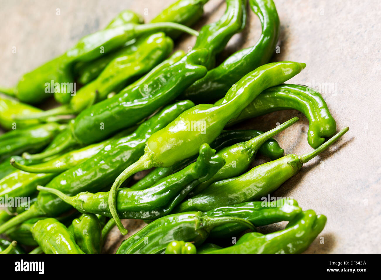 Closeup horizontal photo of fresh, green sweet peppers on stone counter top Stock Photo