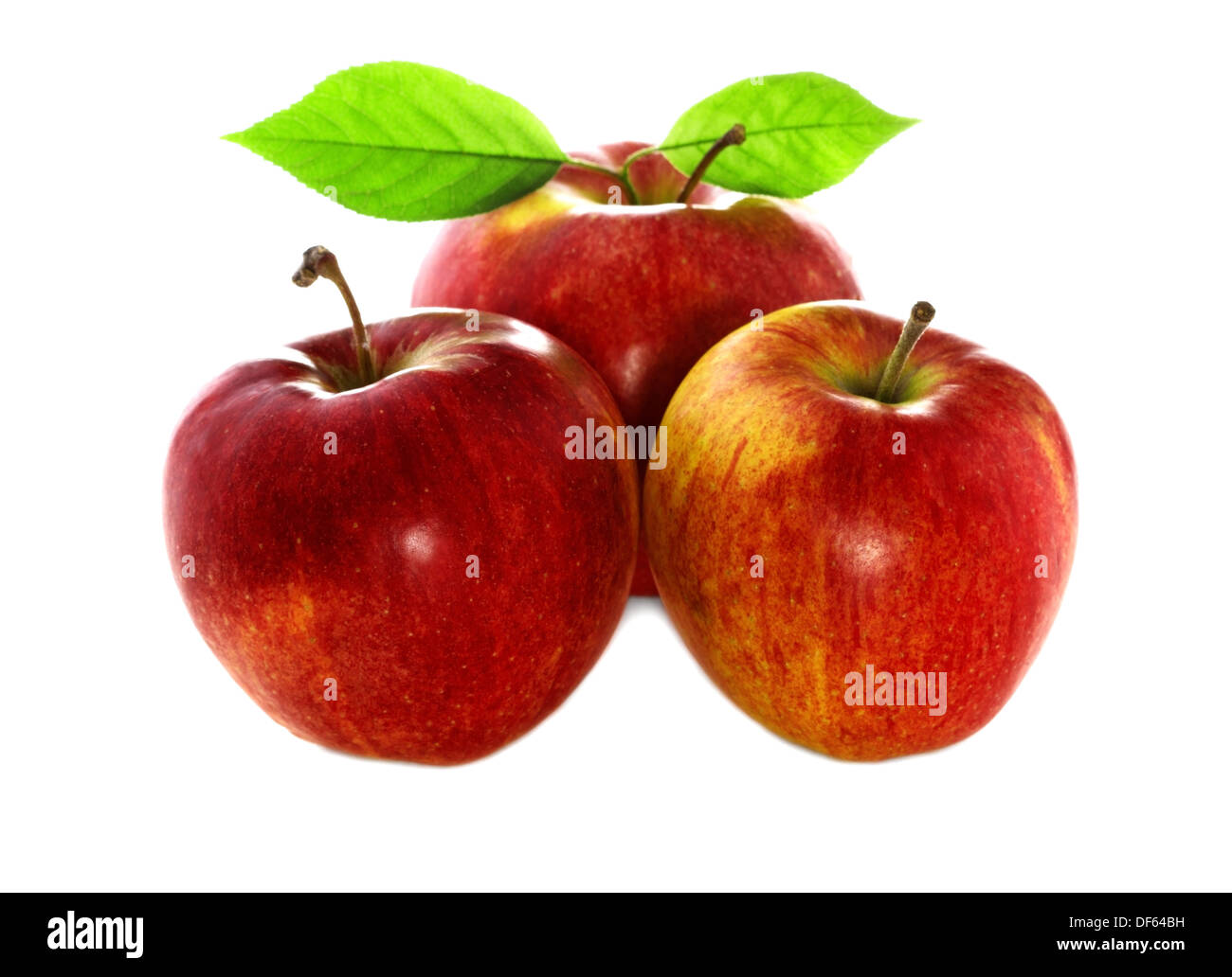 three ripe red and fresh apples with leaves close-up. Isolated on a white background. Stock Photo