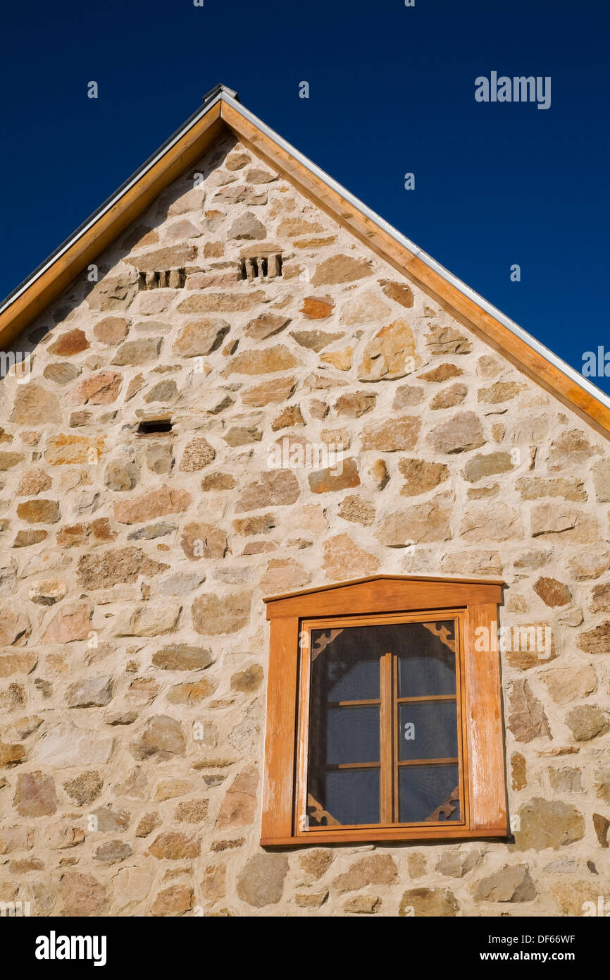 View of the side wall on an old Canadiana cottage style Fieldstone residential home, Quebec, Canada  This image is property Stock Photo