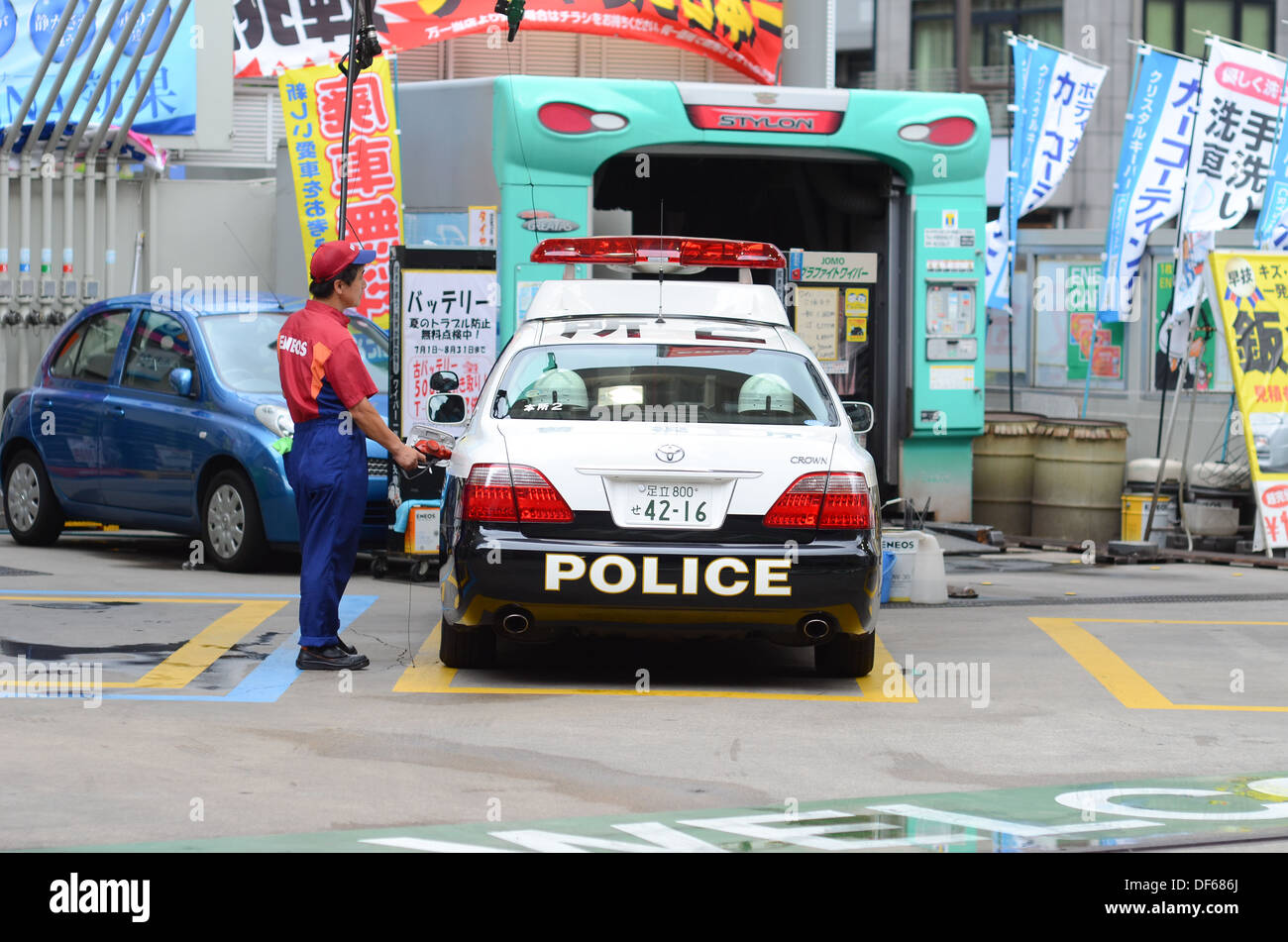 A police car in Japan stopped at a gas station for petrol. Stock Photo