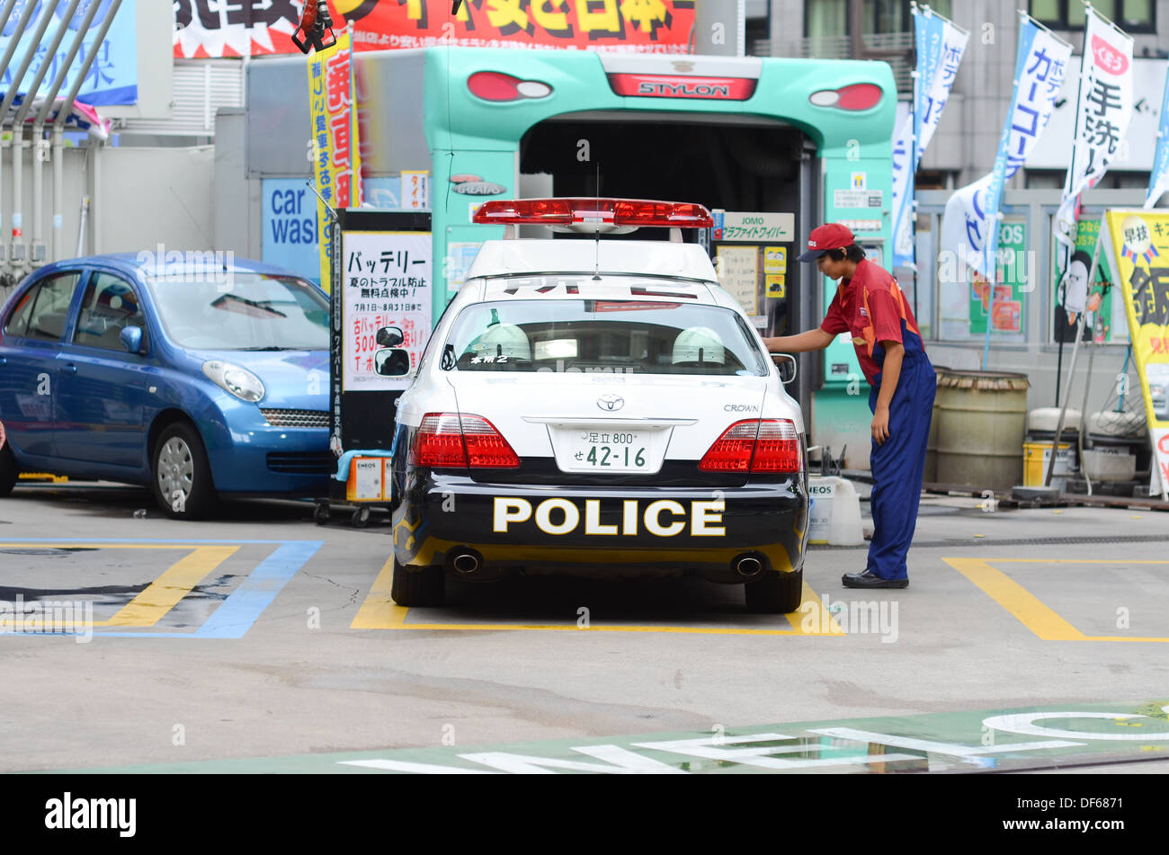 A police car in Japan stopped at a gas station for petrol. Stock Photo