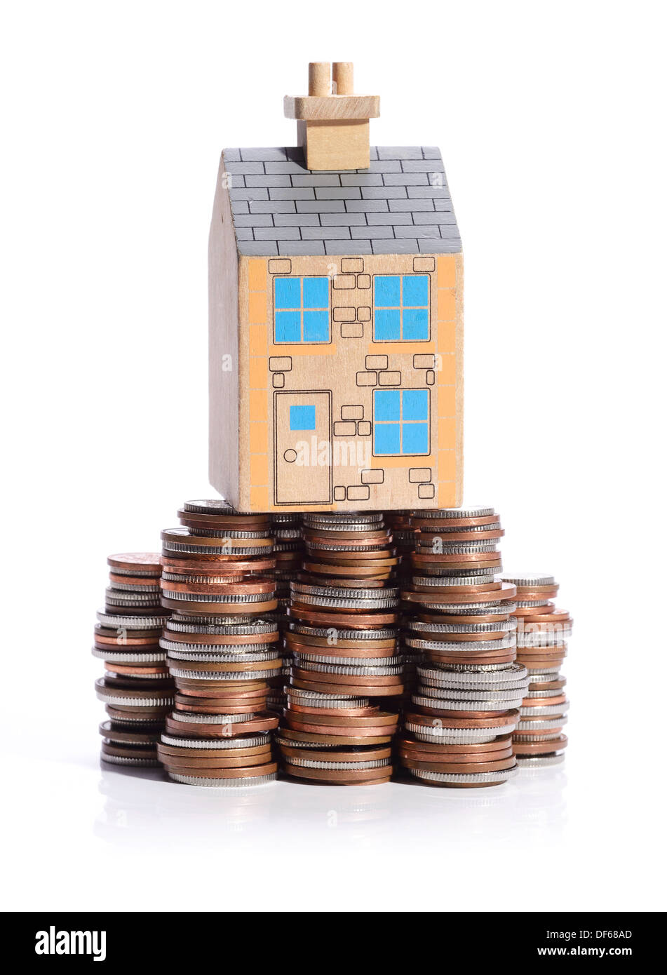 Model wooden house sitting on a pile of money Stock Photo