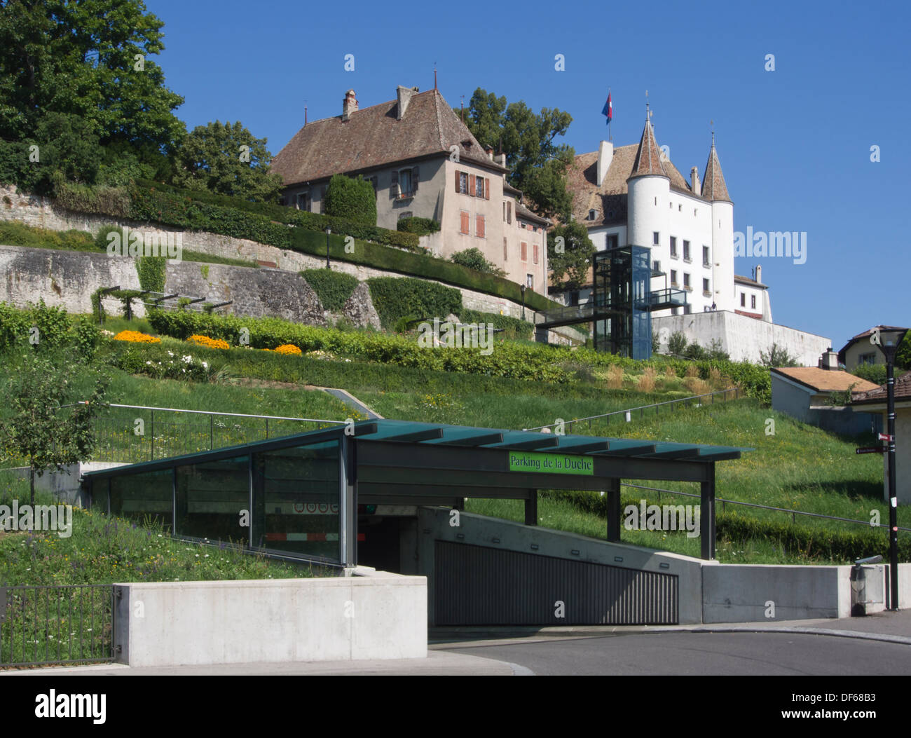 Nyon, town on the shores of Lake Geneva in Switzerland, medieval castle above and parking garage for visitors below vineyard Stock Photo