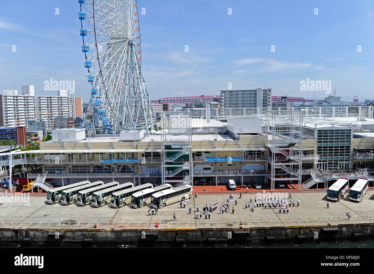 The main cruse docking quay at Kagoshima in Japan with waiting tourist buses and ferris wheel Stock Photo