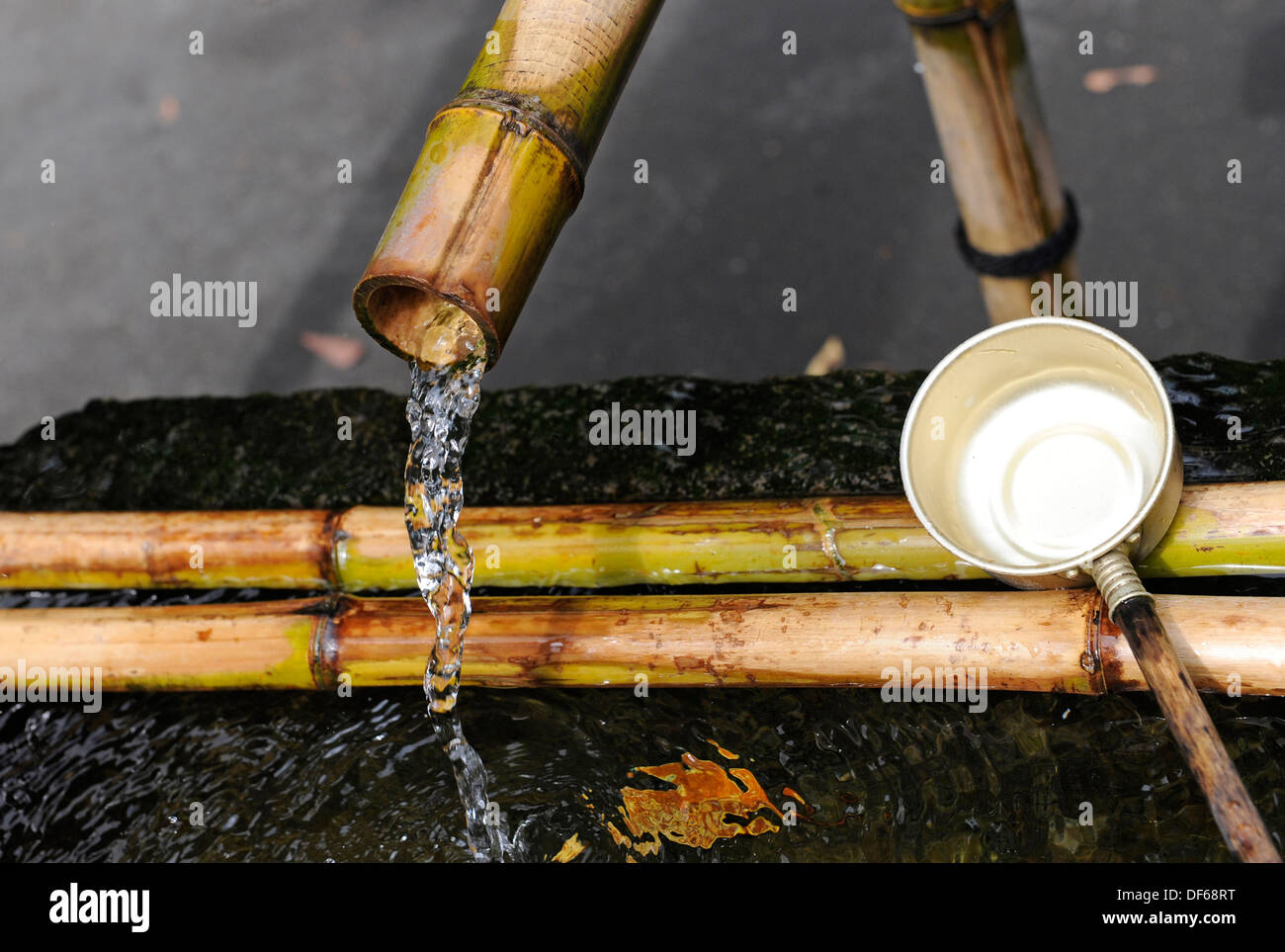 Long handled drinking and washing metal cups with fresh water. Stock Photo