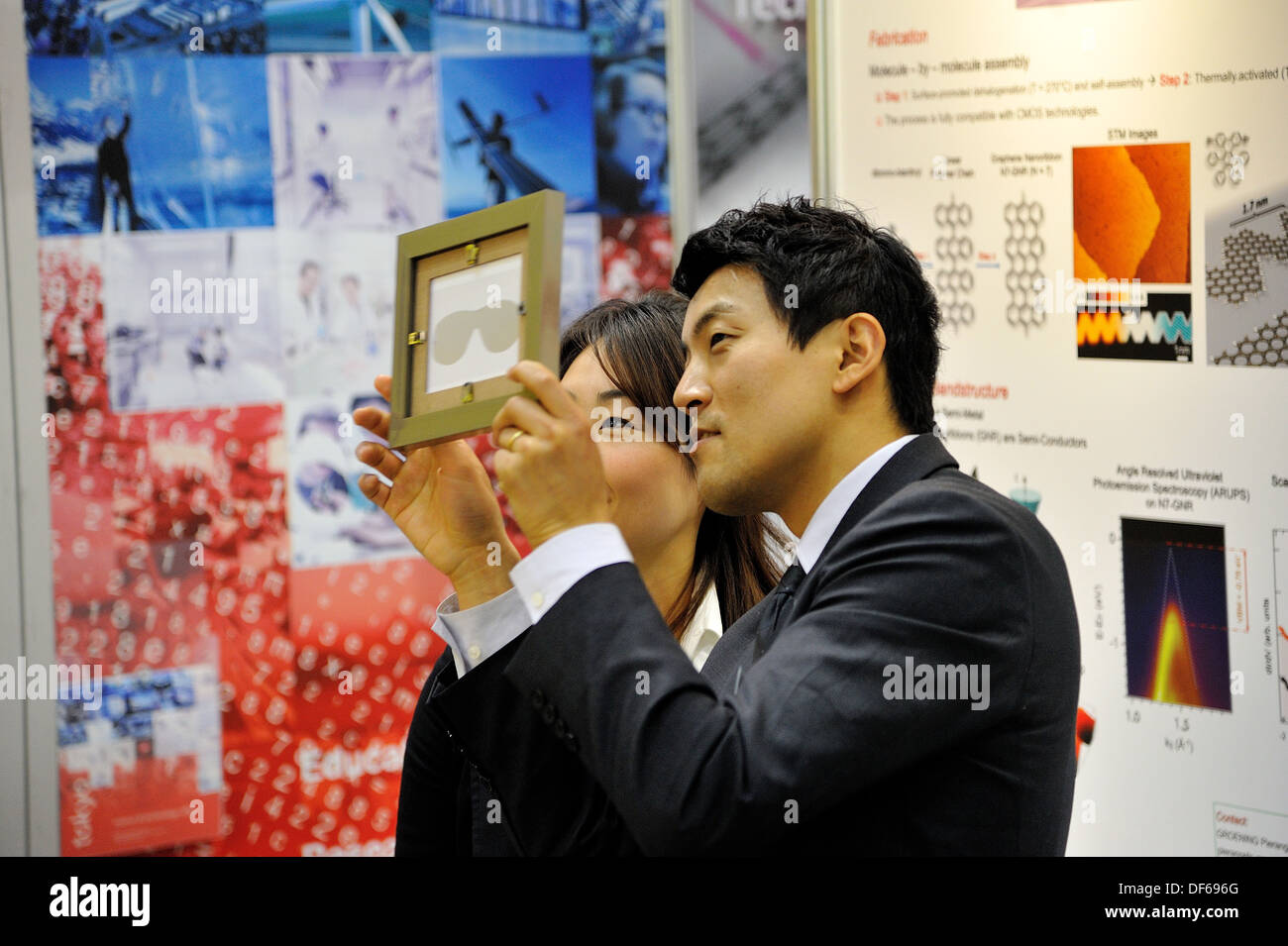 Colleagues examine a vision mask demonstrator at the Nanotech Japan trade fair in Tokyo Stock Photo