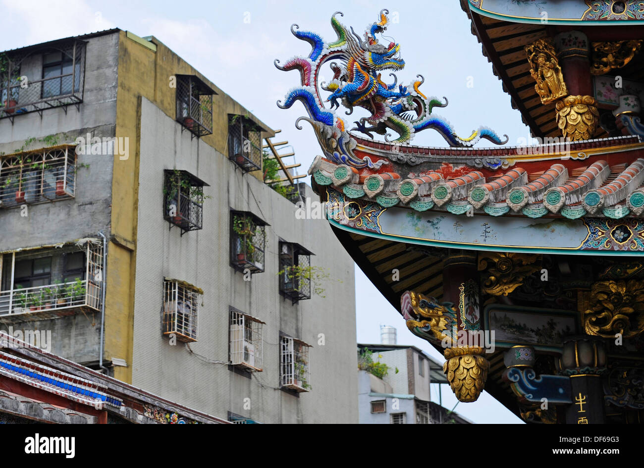 The fine decorative sculptures and Architecture of the Baoan temple juxtaposition along side the bland flats made from concrete. Stock Photo