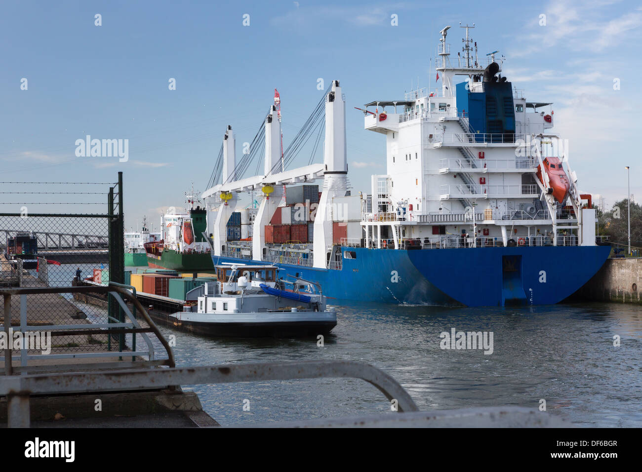 Cargo ship and container barges passing the Zandvliet lock in Antwerp