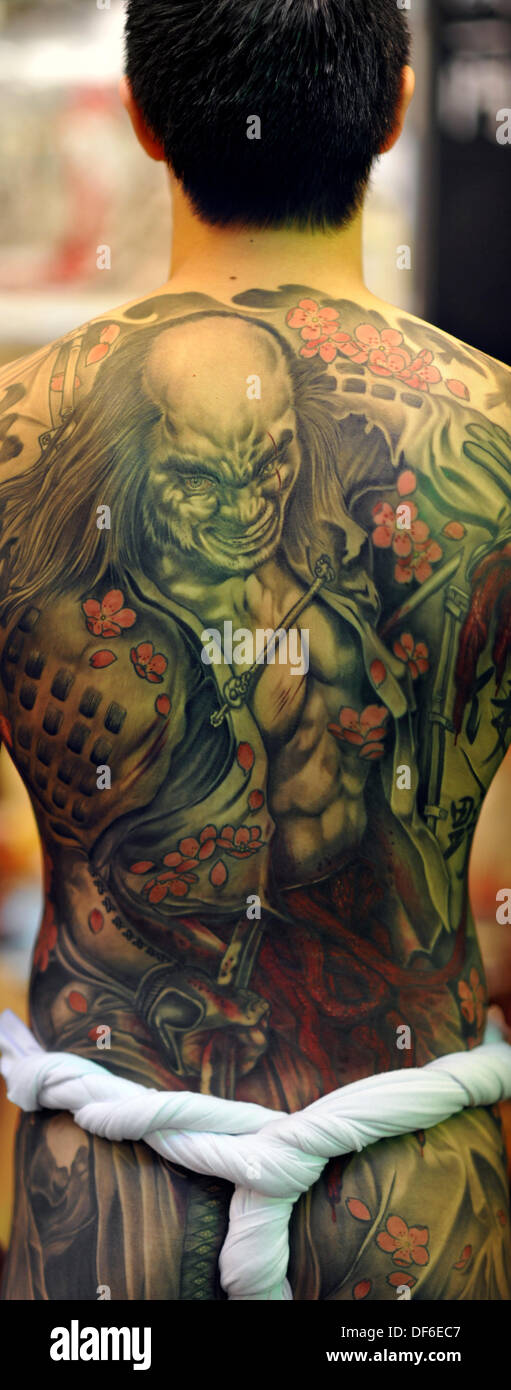 London, UK. 28 Sept 2013. A dramatic, Japanese style, whole back tattoo featuring the act of seppuku at the 9th International London Tattoo Convention. Whole back tattoos are normally very involved and can take 20 hours or more to complete. © Michael Preston/Alamy Live News Stock Photo