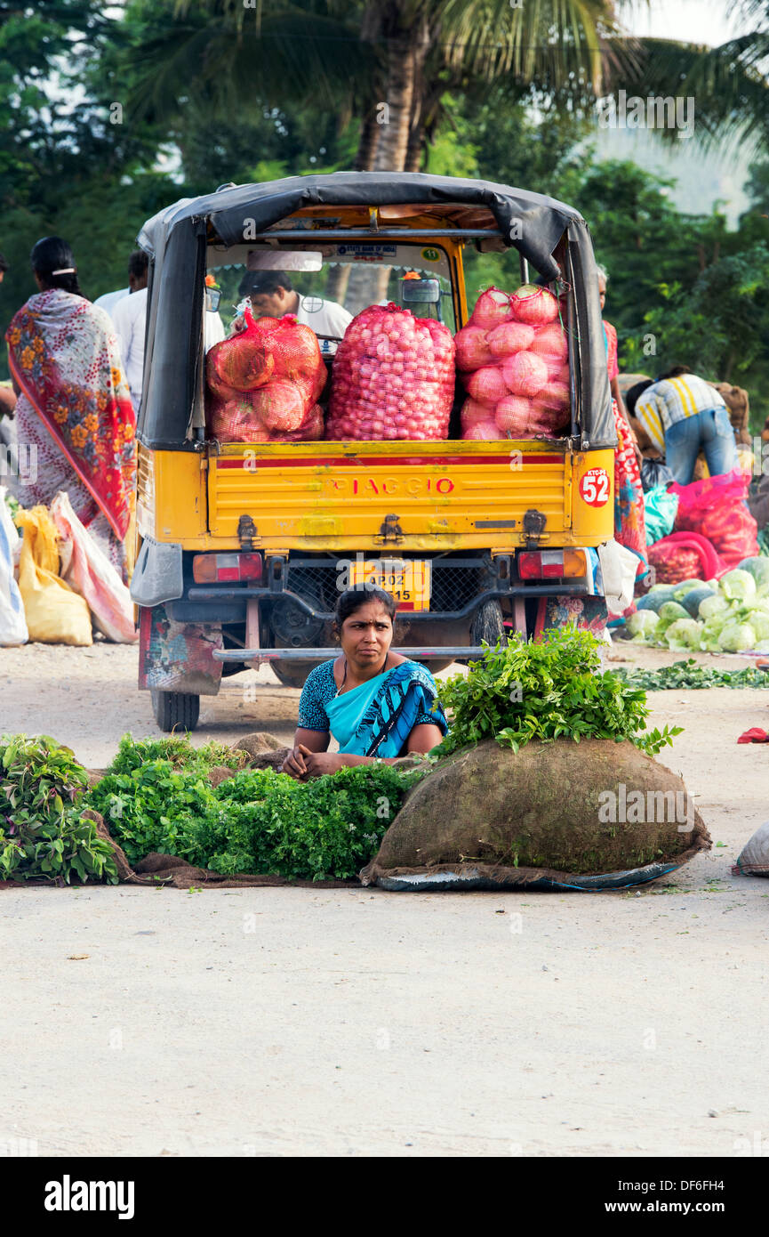 Indian woman selling herbs and leaf vegetables from sacks at a street market.  Puttaparthi, Andhra Pradesh, India Stock Photo