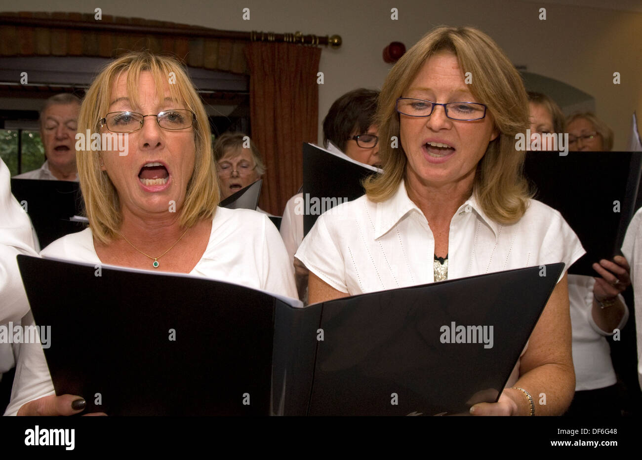 Members of a local choir entertaining visitors at a Macmillan Cancer Support Coffee Morning, Farnham, Surrey, UK. Stock Photo