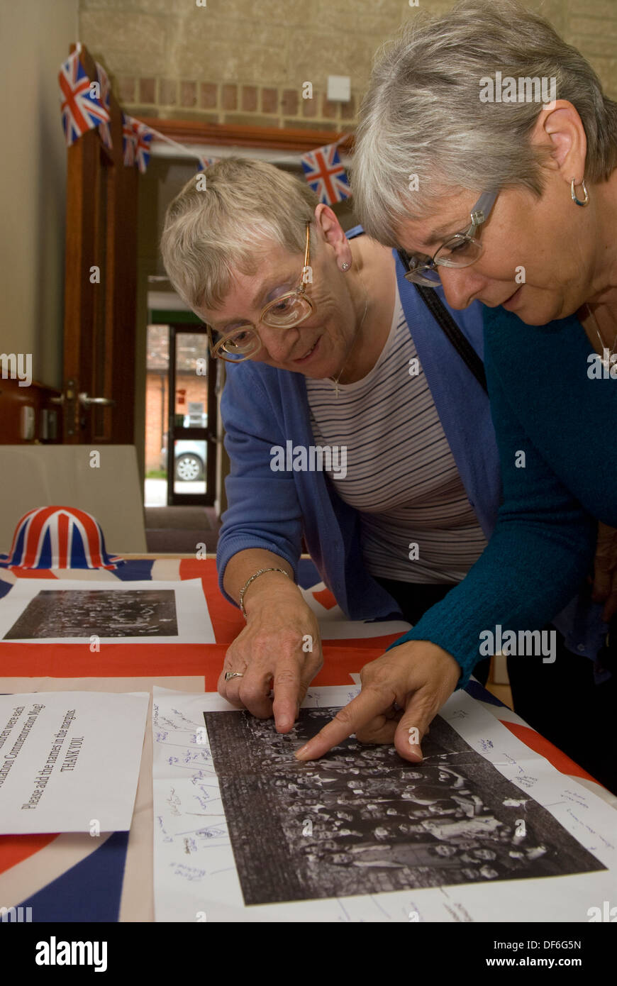 Two elderly women browsing old photographs at a village history open ...