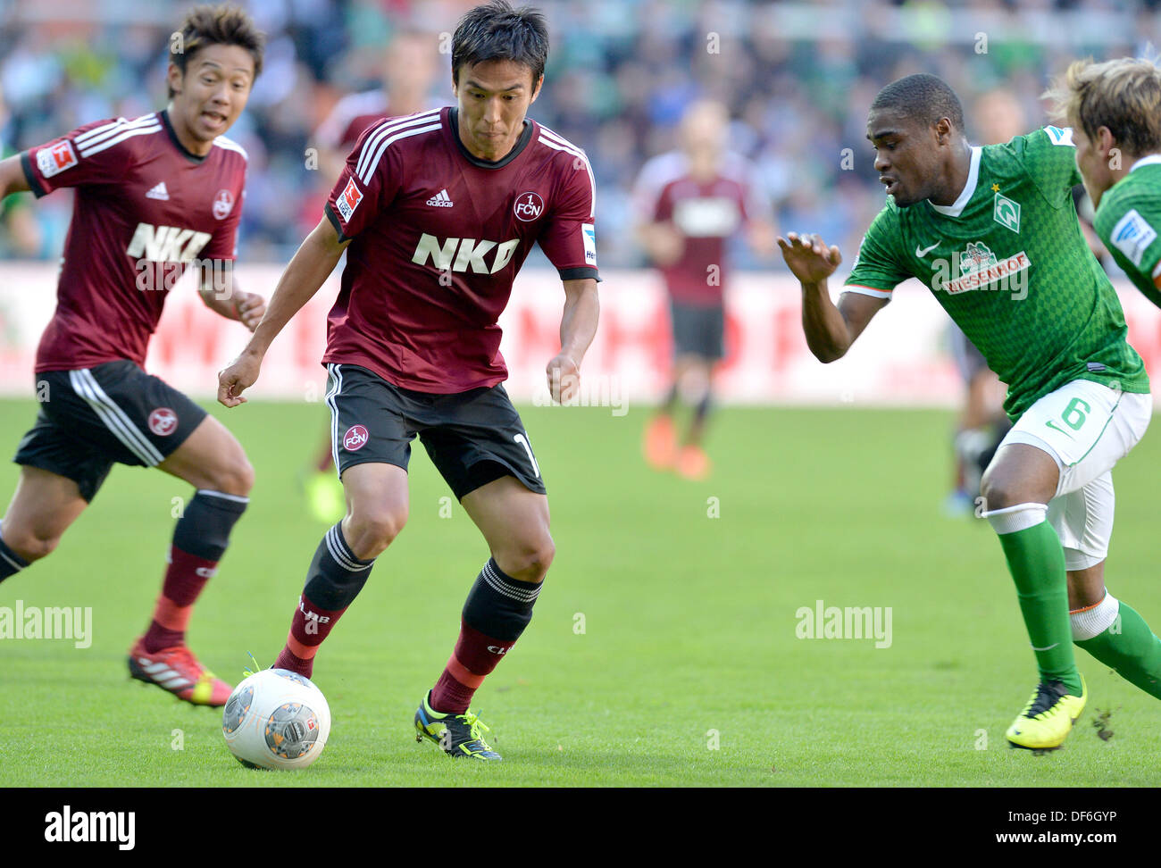 Bremen's Cedric Makiadi (R) vies for the ball with Nuremberg's Makoto Hasebe and Hiroshi Kiyotake (L) during the German Bundesliga match between Werder Bremen and FC Nuremberg at Weser Stadium in Bremen, Germany, 29 September 2013. Photo: CARMEN JASPERSEN (ATTENTION: Due to the accreditation guidelines, the DFL only permits the publication and utilisation of up to 15 pictures per match on the internet and in online media during the match.) Stock Photo