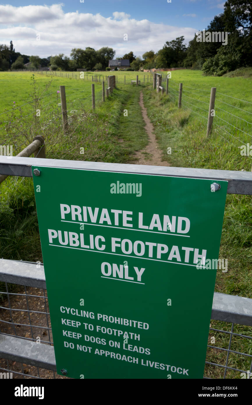 A sign indicating that the footpath ahead crosses private land in Suffolk, England. Stock Photo
