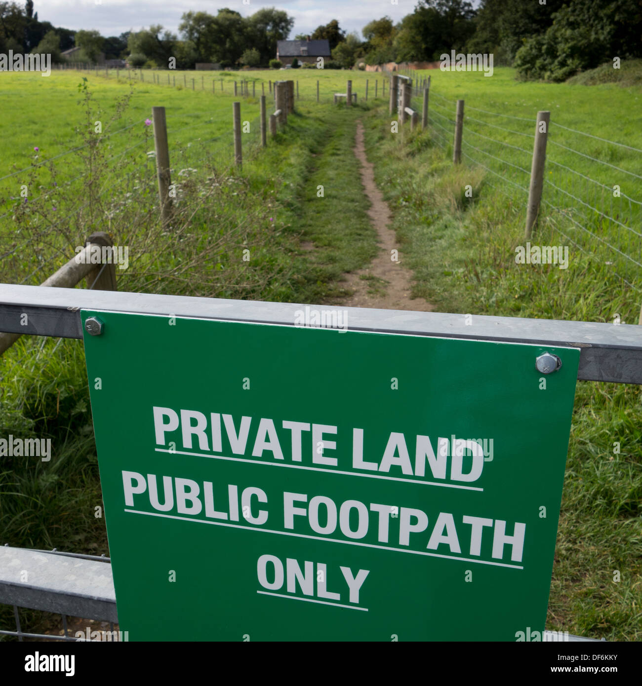 A sign indicating that the footpath ahead crosses private land in Suffolk, England. Stock Photo