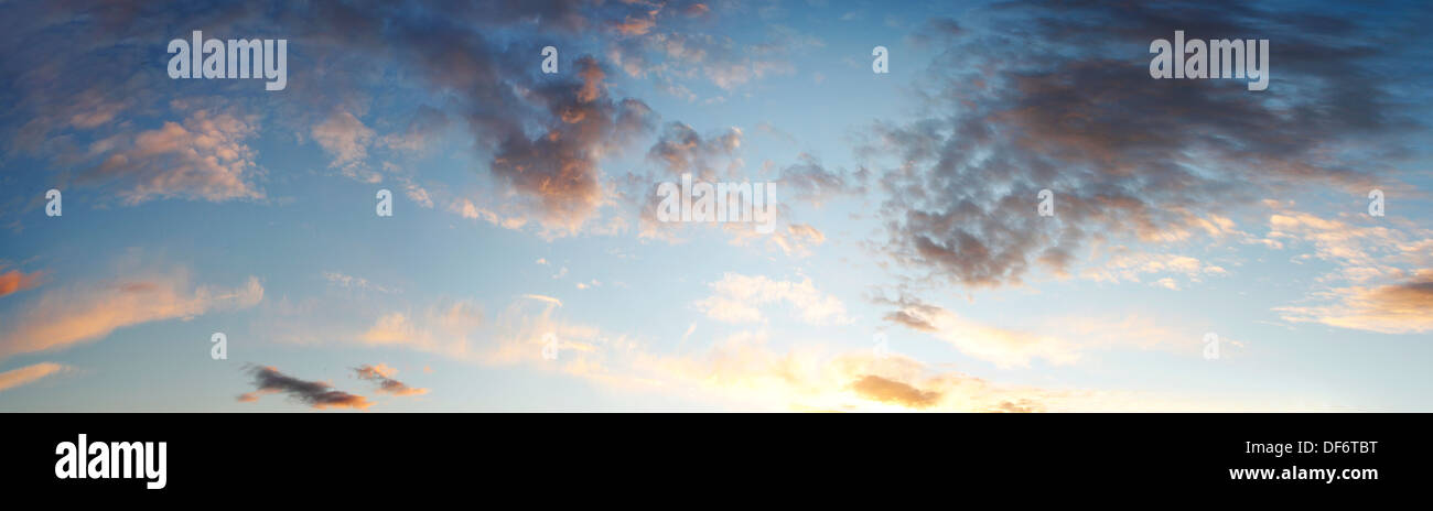 Fluffy clouds in blue sky at sunset Stock Photo