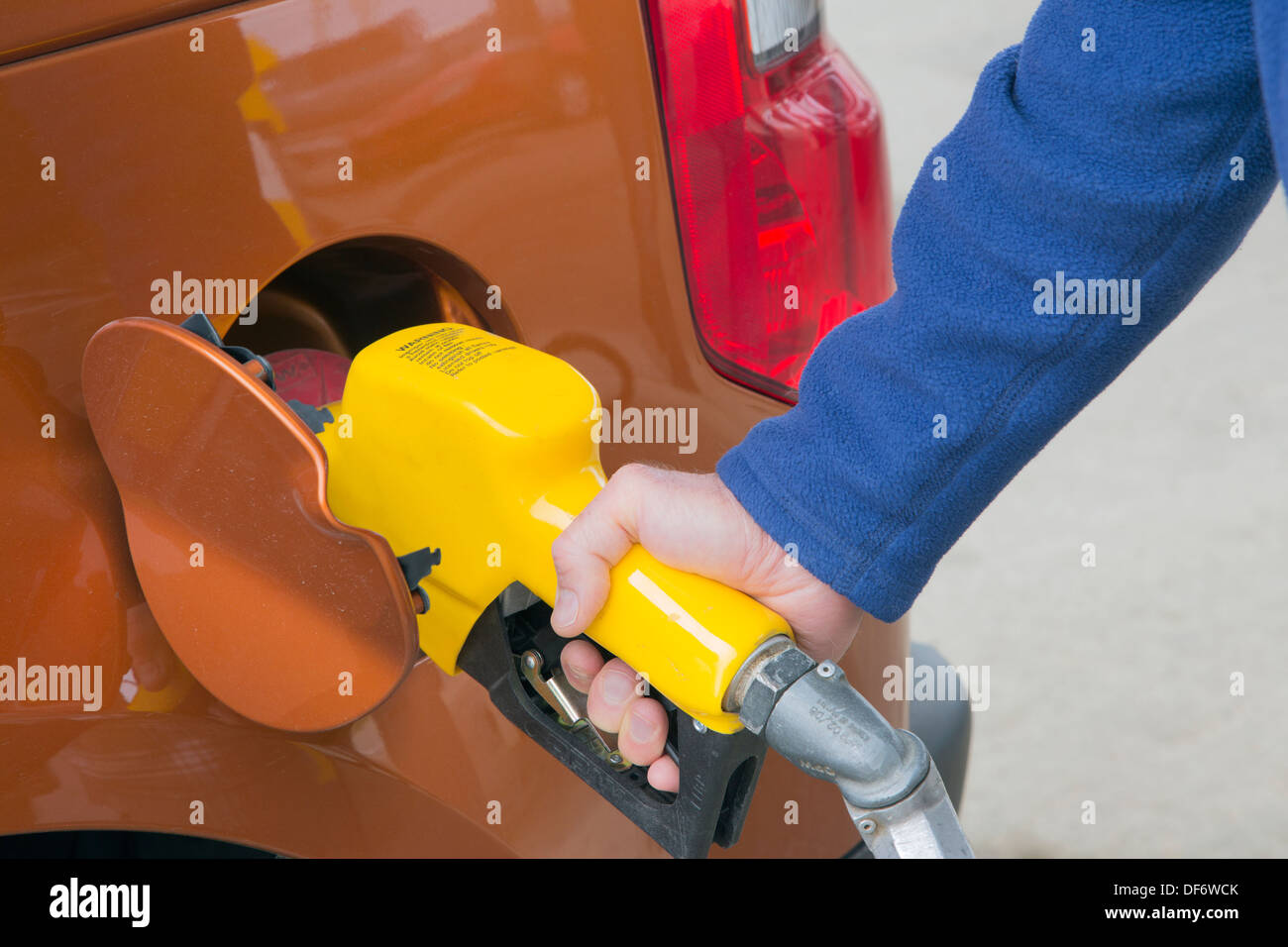 Man pumping gas into his vehicle at service station Stock Photo