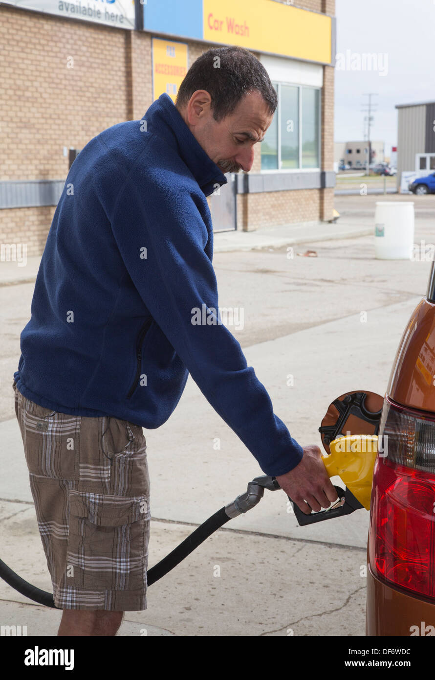 Man pumping gas into his vehicle at service station Stock Photo