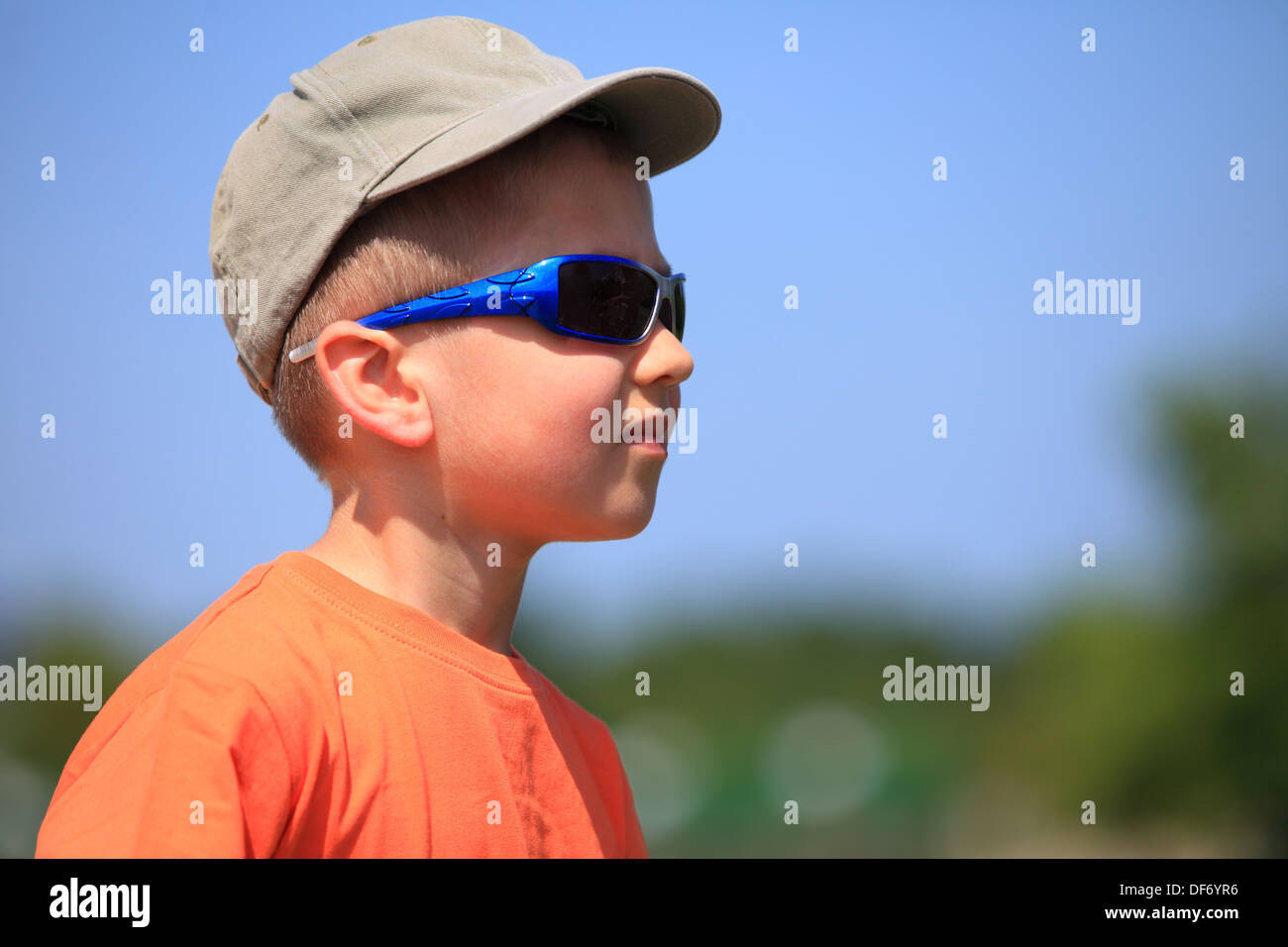 Little boy kid with sunglasses and cap outdoor sky background Stock