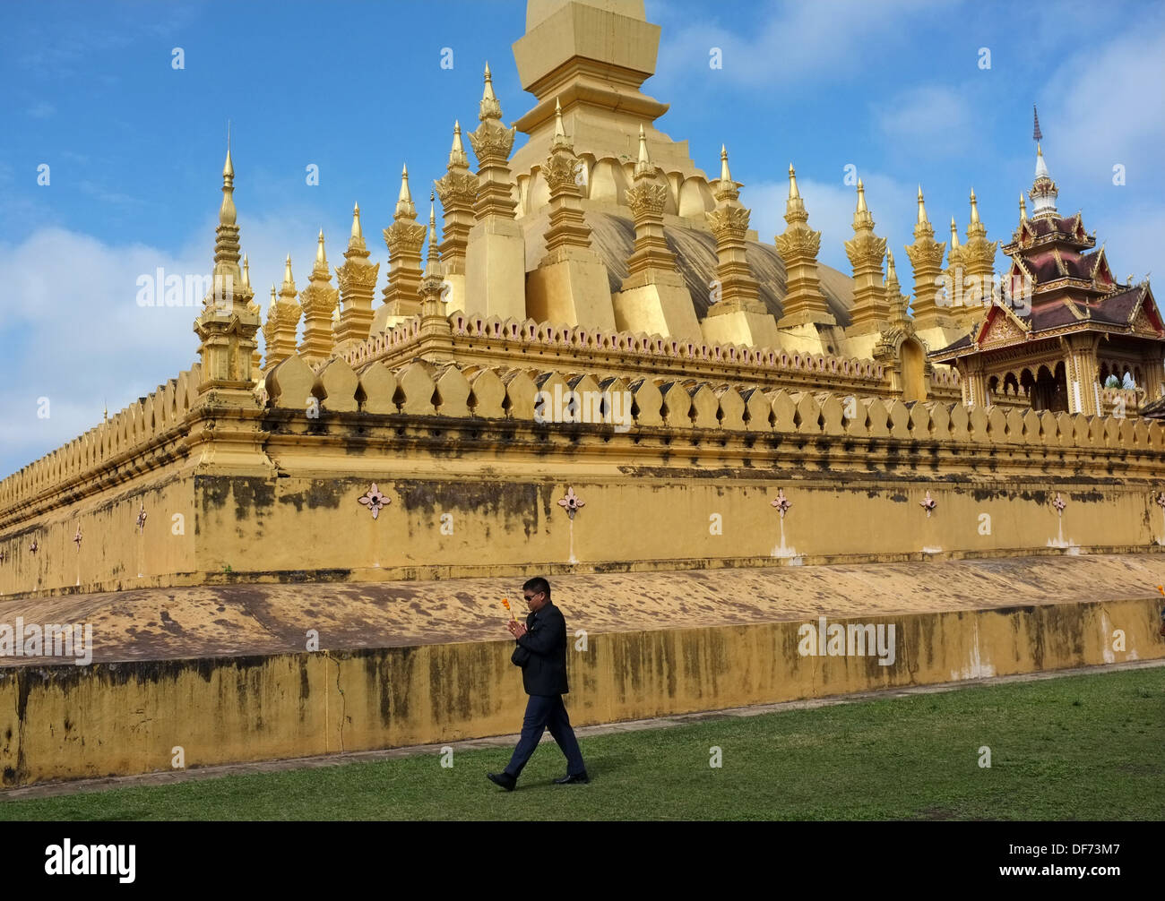 Buddhist worshiper praying at Pha That Luang in Vientiane, Laos Stock Photo