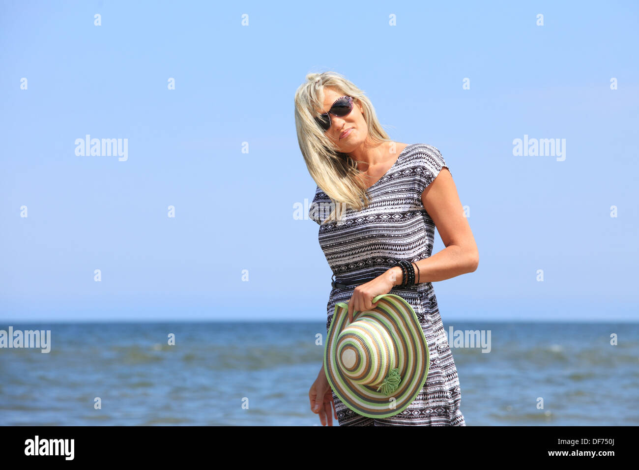 mature woman with hat on beach enjoying summer holiday Stock Photo - Alamy