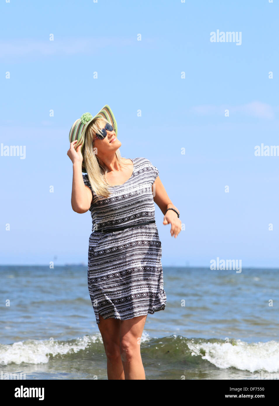 mature woman with hat on beach enjoying summer holiday Stock Photo - Alamy