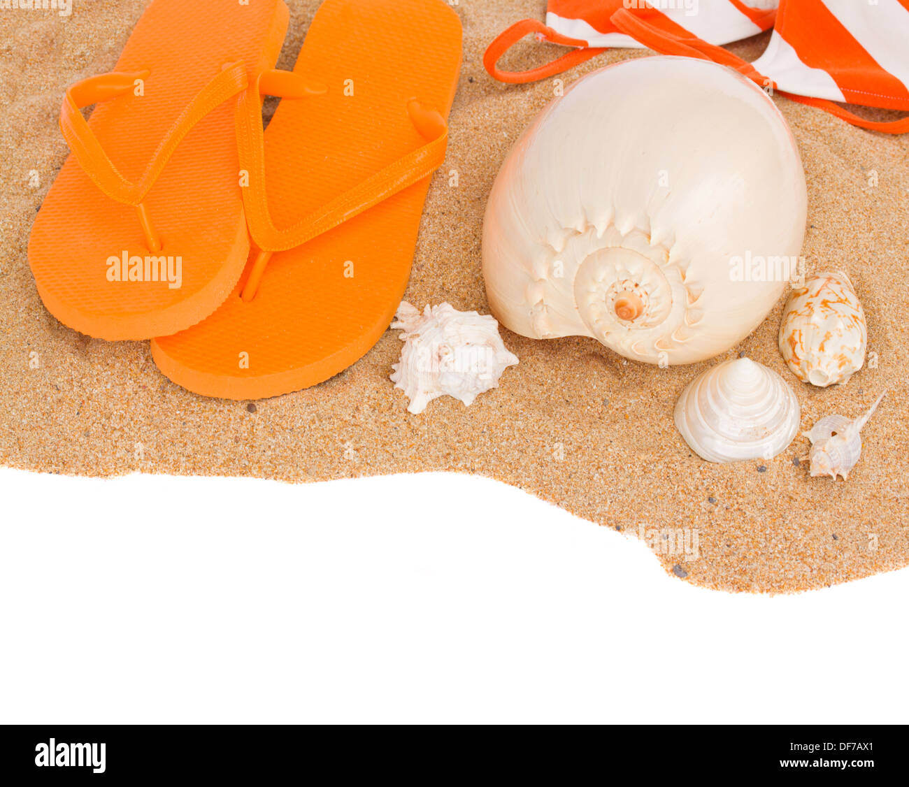 orange sandals and seashells on sand Stock Photo