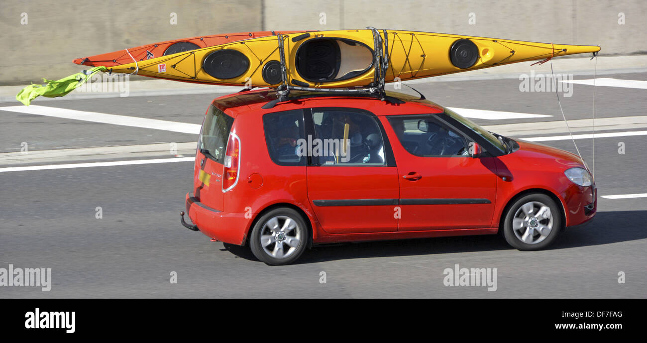 Car roof rack loaded with two kayak canoes driving along motorway Stock Photo Alamy