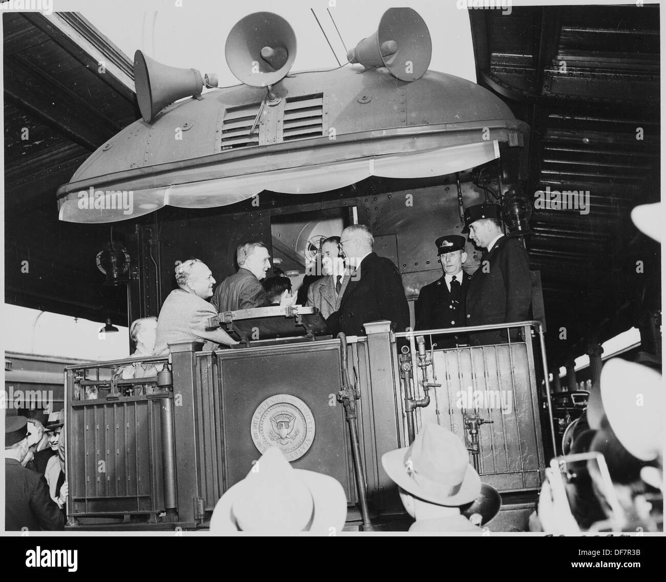 President Harry S. Truman and Vice President-elect Alben W. Barkley greet two unidentified men on the rear platform... 199943 Stock Photo