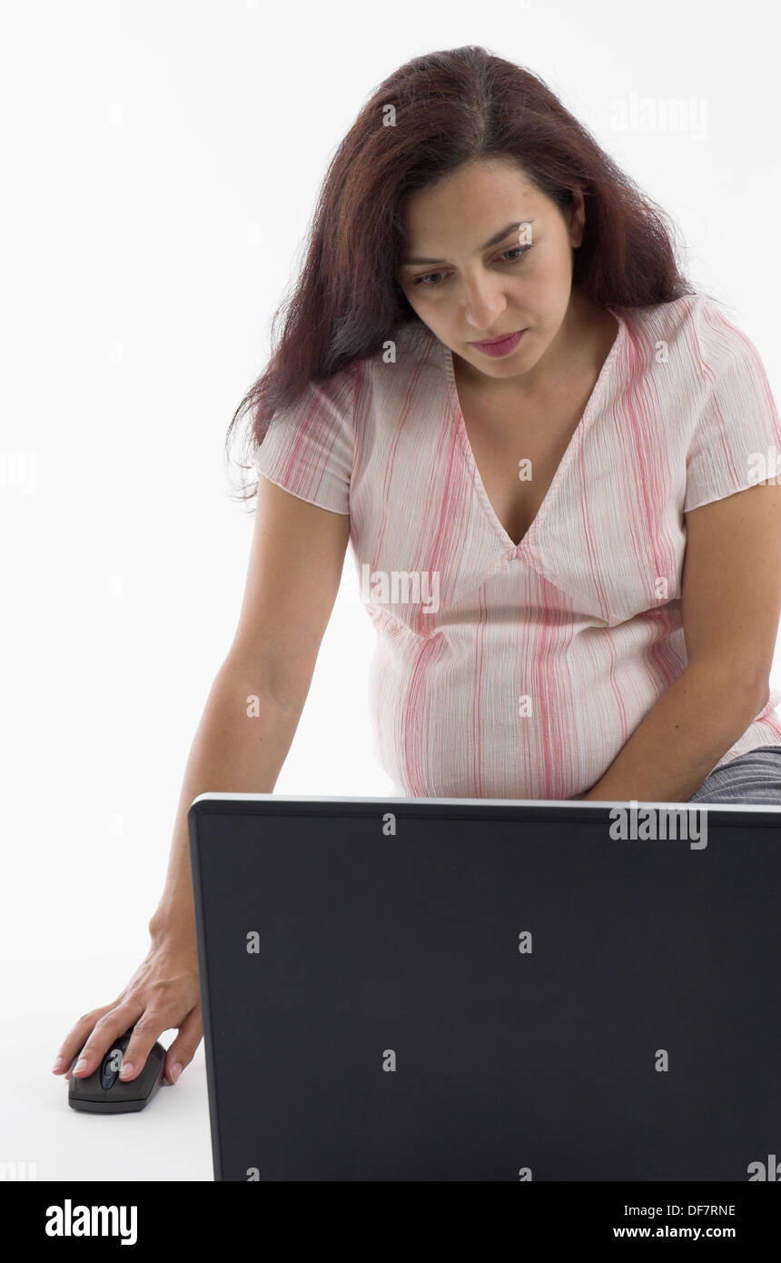 Young woman in the early stages of pregnancy using a laptop computer