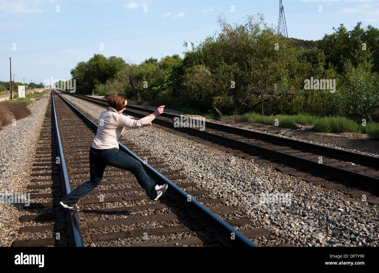 Girl walking on train tracks Stock Photo Alamy