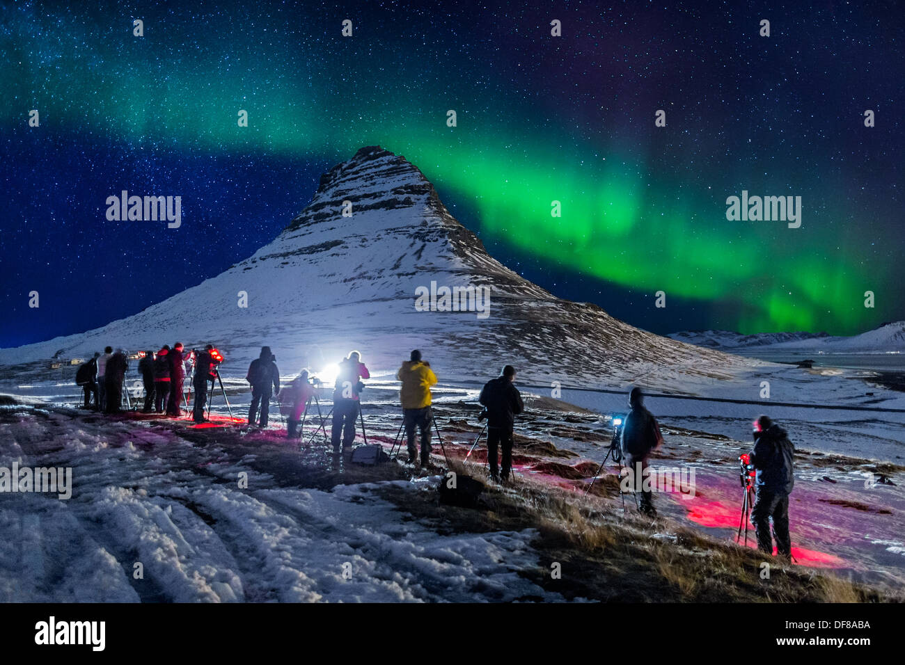 People taking pictures of the Aurora Borealis or Northern lights over Mt Kirkjufell, Snaefellsnes Peninsula, Iceland Stock Photo