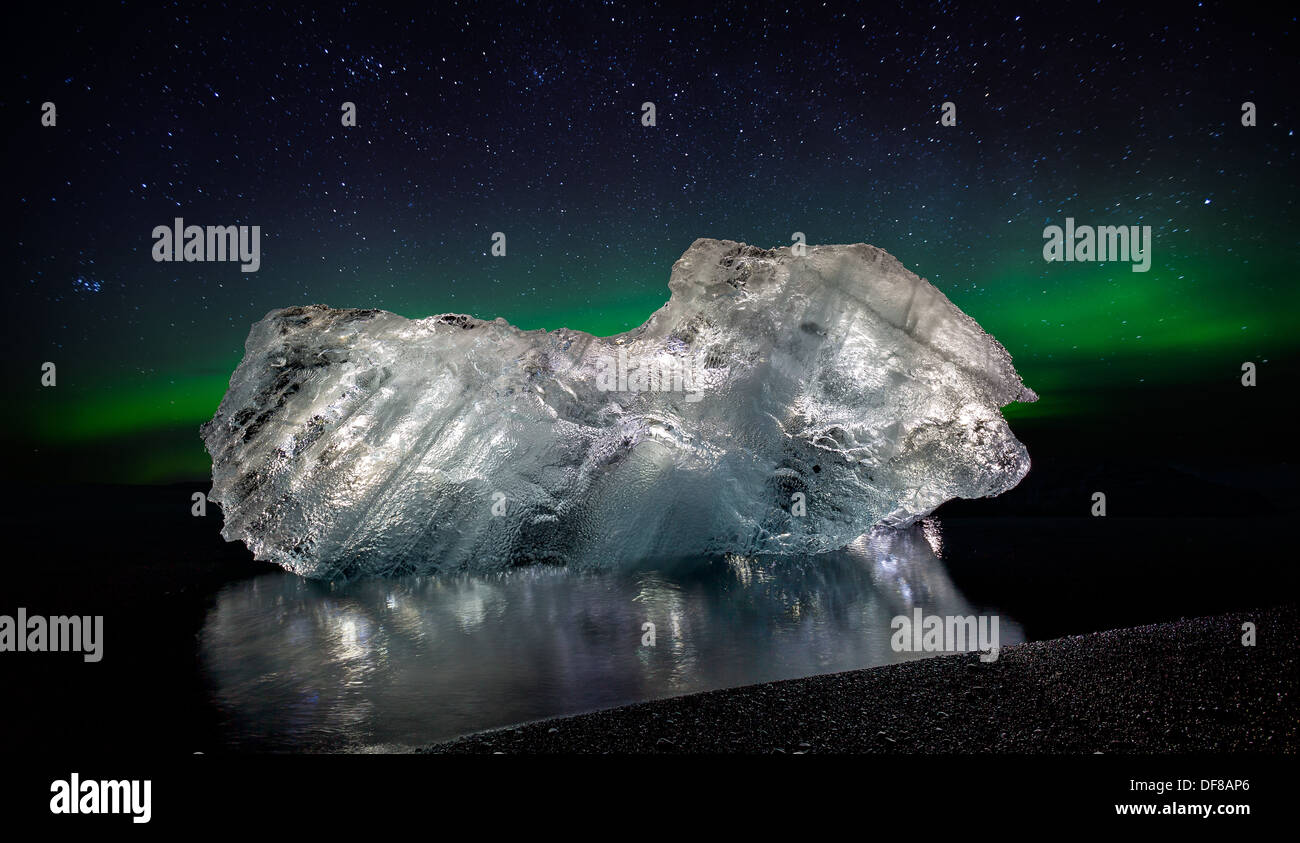 Ice on black sands with the Aurora Borealis or Northern lights, Iceland Stock Photo