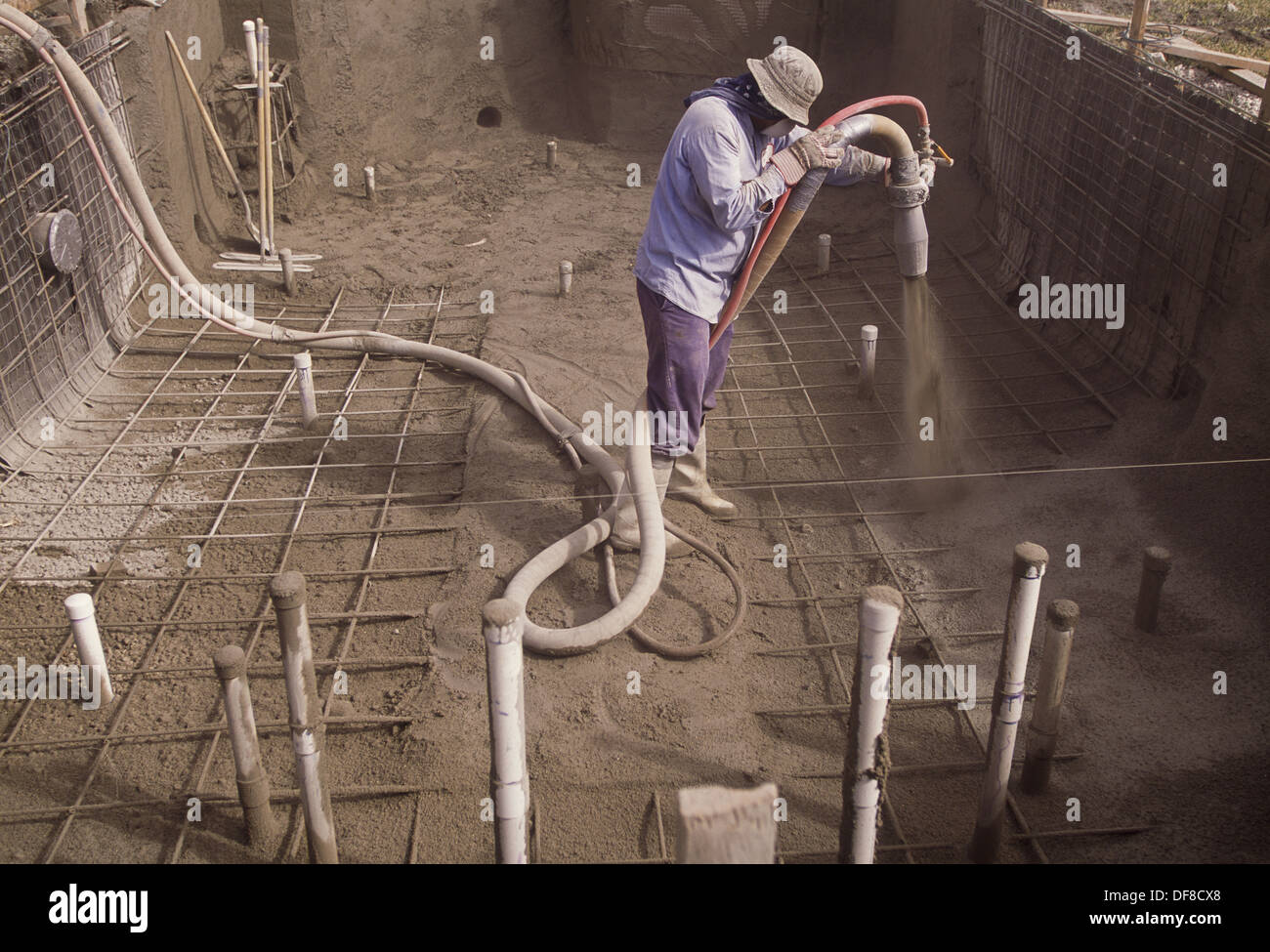 Man spraying concrete to bottom of pool under construction, Florida, USA Stock Photo Alamy