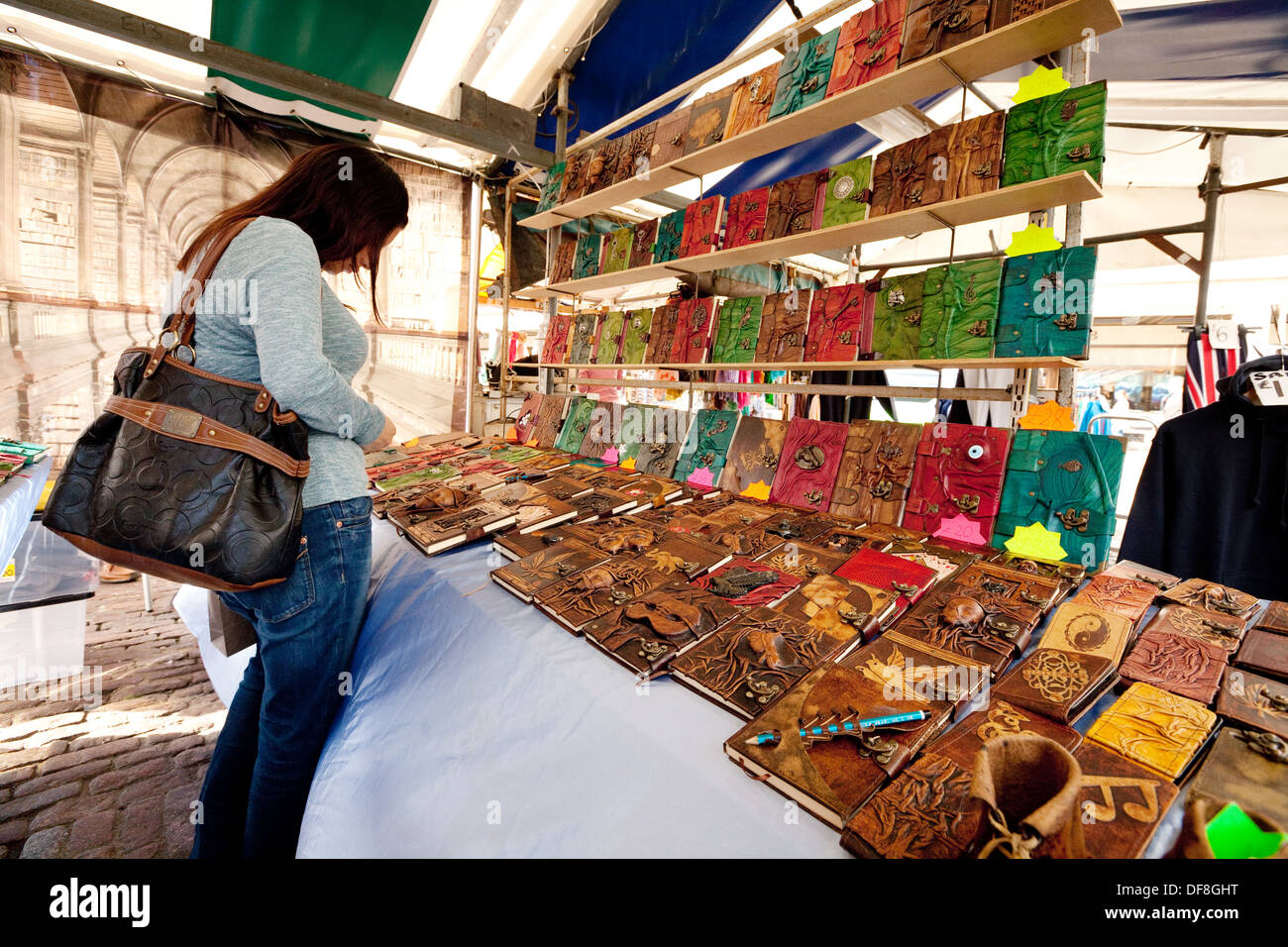 A woman shopping at a craft market stall, buying books, Cambridge market, Cambridge, UK Stock Photo