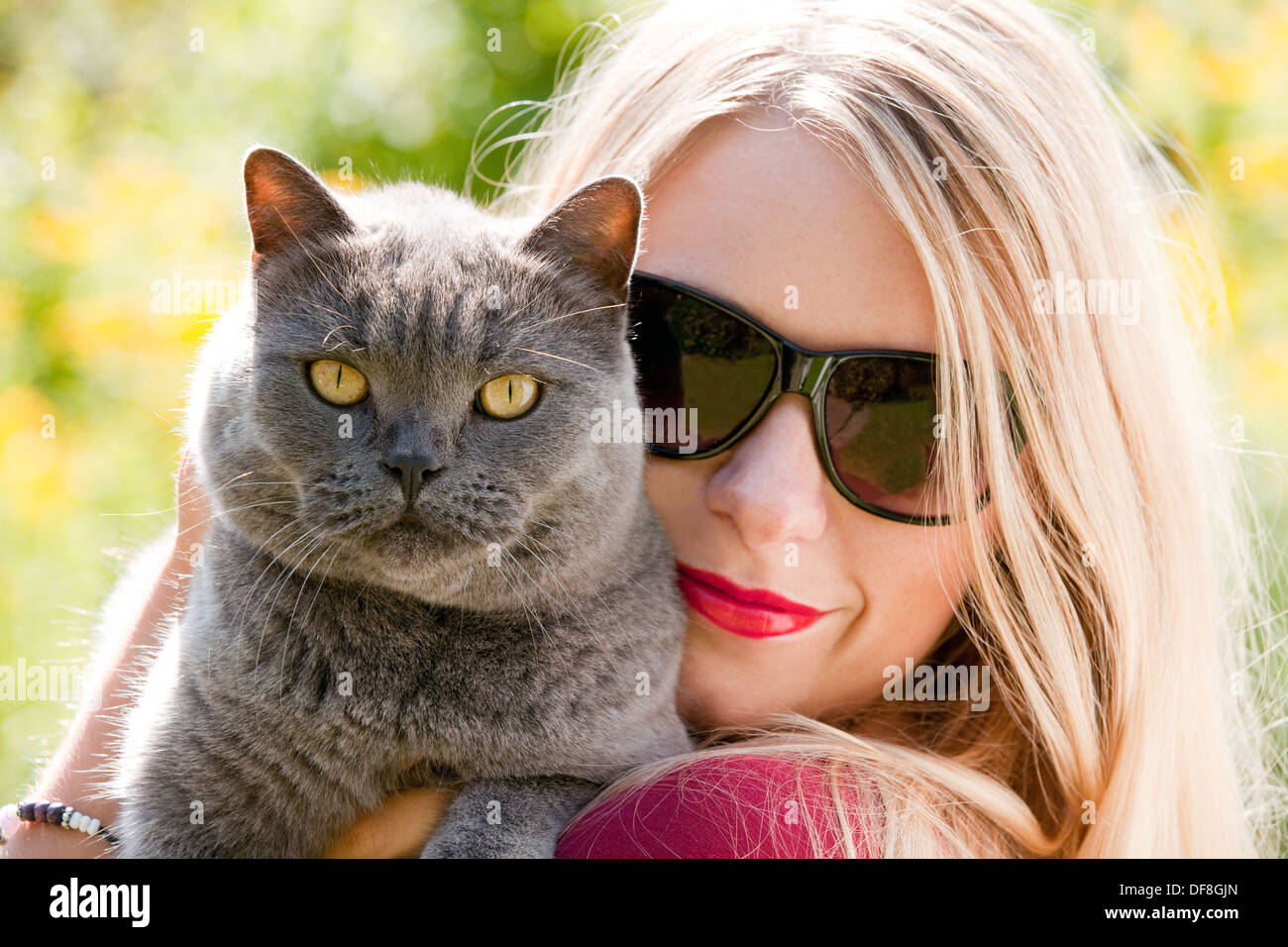 Young blond caucasian woman age 20 years, and her pet cat, UK Stock Photo