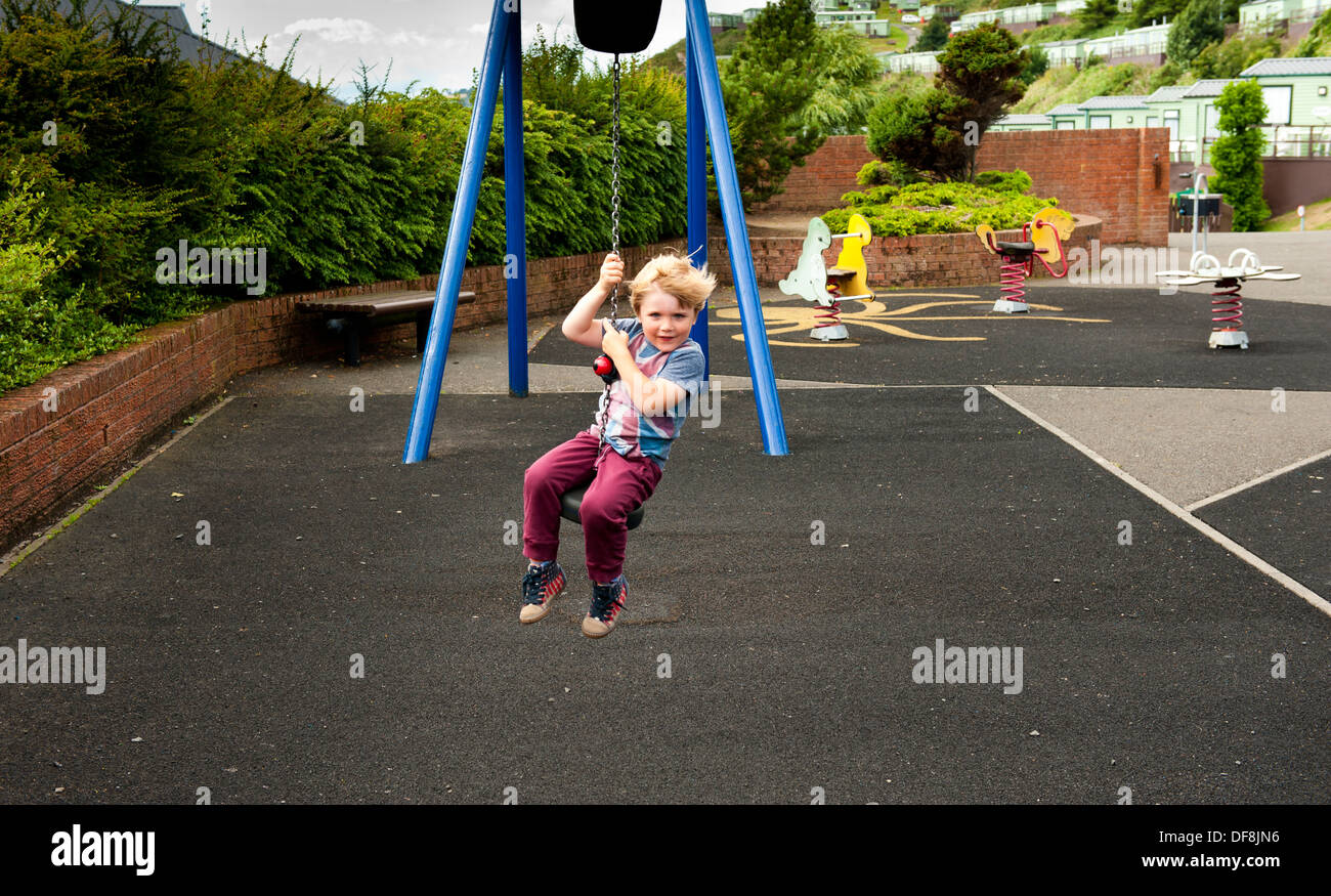 boy sliding in play park having fun Stock Photo