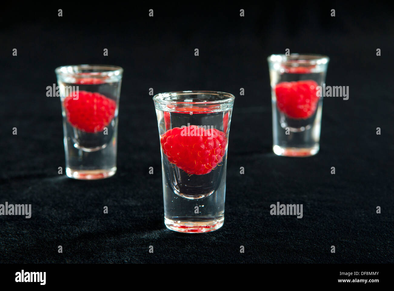 Raspberry shots on a black background. Stock Photo