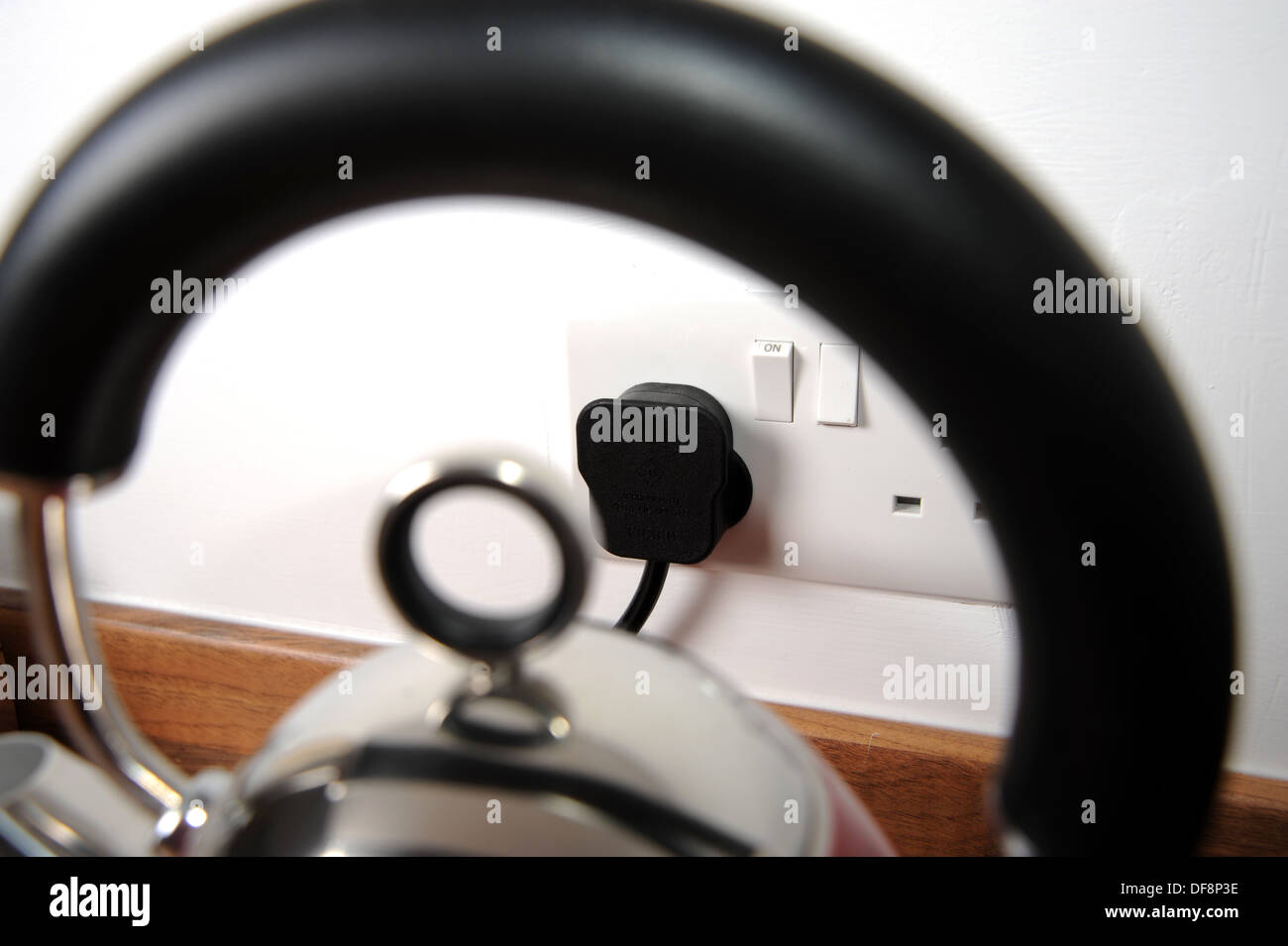 Electric plug socket viewed through kettle handle in kitchen Stock Photo