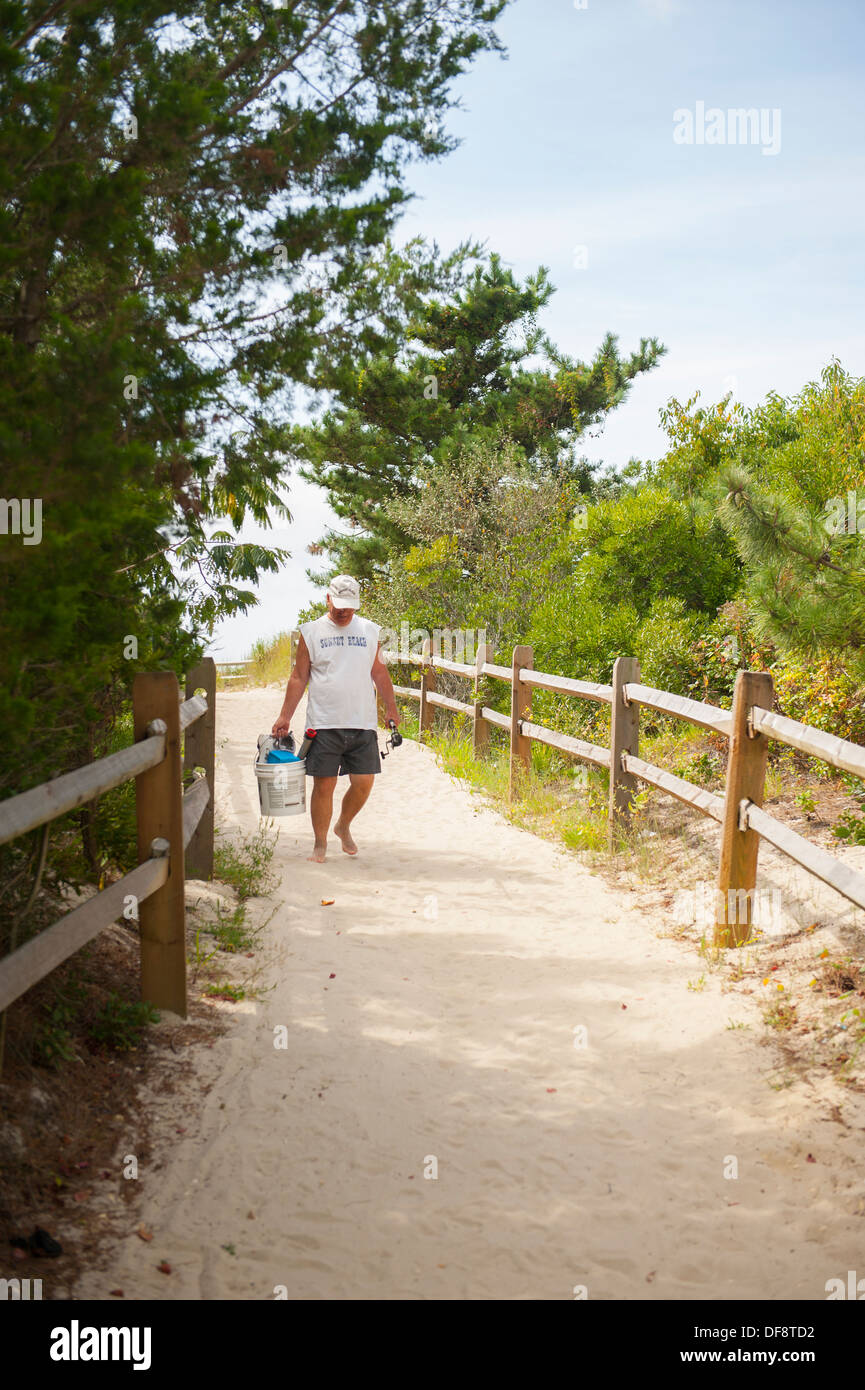 USA New Jersey NJ N.J. Cape May a fisherman walks on a beach path from the ocean Stock Photo
