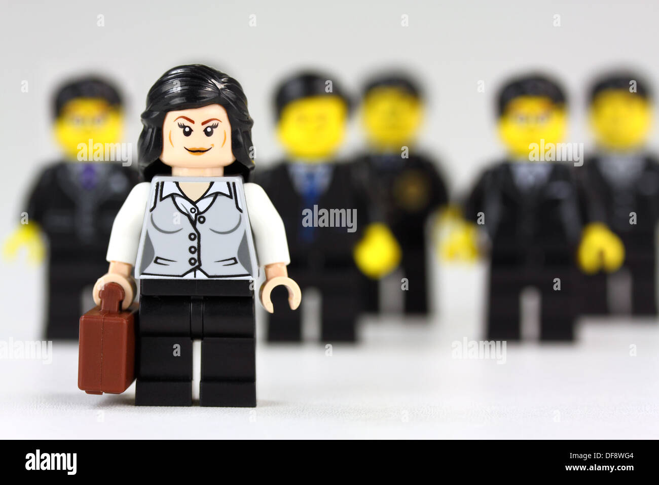 Businesswoman standing out from the crowd of businessmen Stock Photo