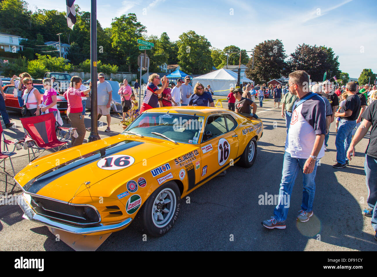 Vintage race cars parked in downtown Watkins Glen during the annual Vintage Race weekend Festival with spectators viewing cars Stock Photo