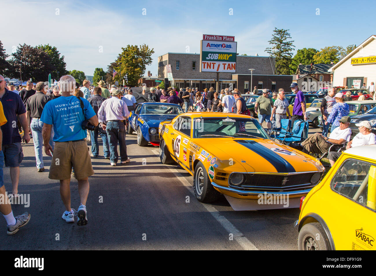 Vintage race cars parked in downtown Watkins Glen during the annual Vintage Race weekend Festival with spectators viewing cars Stock Photo