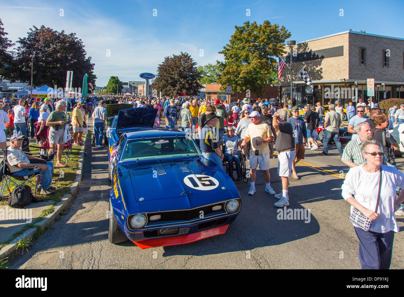 Vintage race cars parked in downtown Watkins Glen during the annual Vintage Race weekend Festival with spectators viewing cars Stock Photo