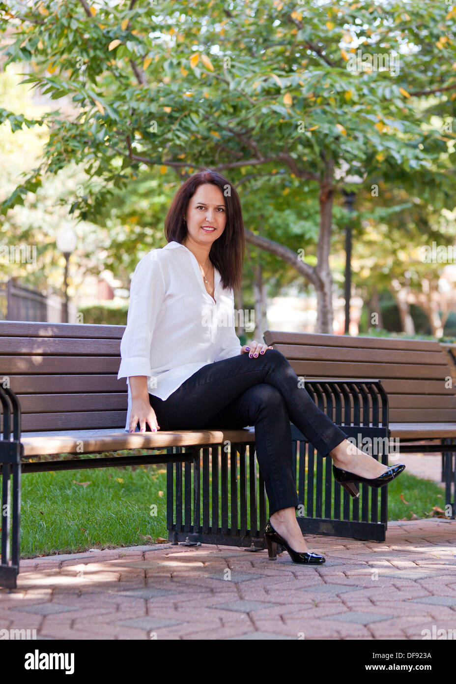 Woman sitting on park bench hi-res stock photography and images - Alamy